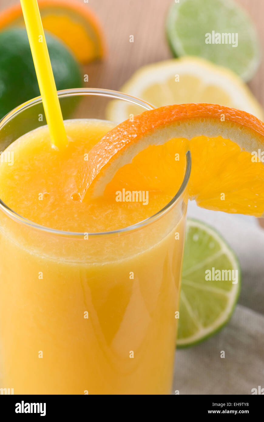 Un verre de jus d'orange avec de la paille et une tranche d'orange. Banque D'Images