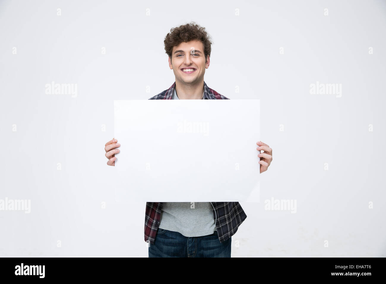 Homme heureux avec les cheveux bouclés holding blank billboard Banque D'Images