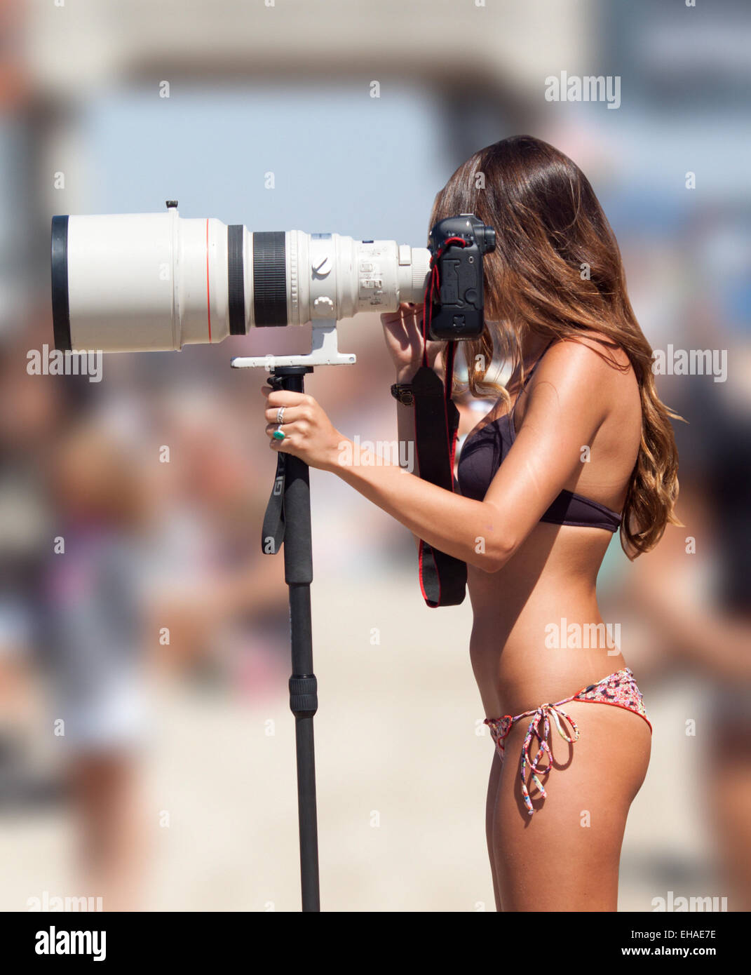 Femme photographe à la plage avec un super-téléobjectif Banque D'Images