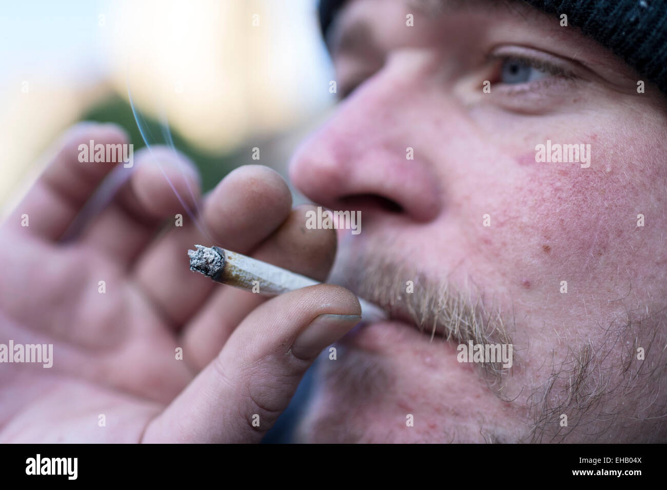 Un homme fumer un joint à l'aide de tabac et heureux joker, un haut juridique Banque D'Images