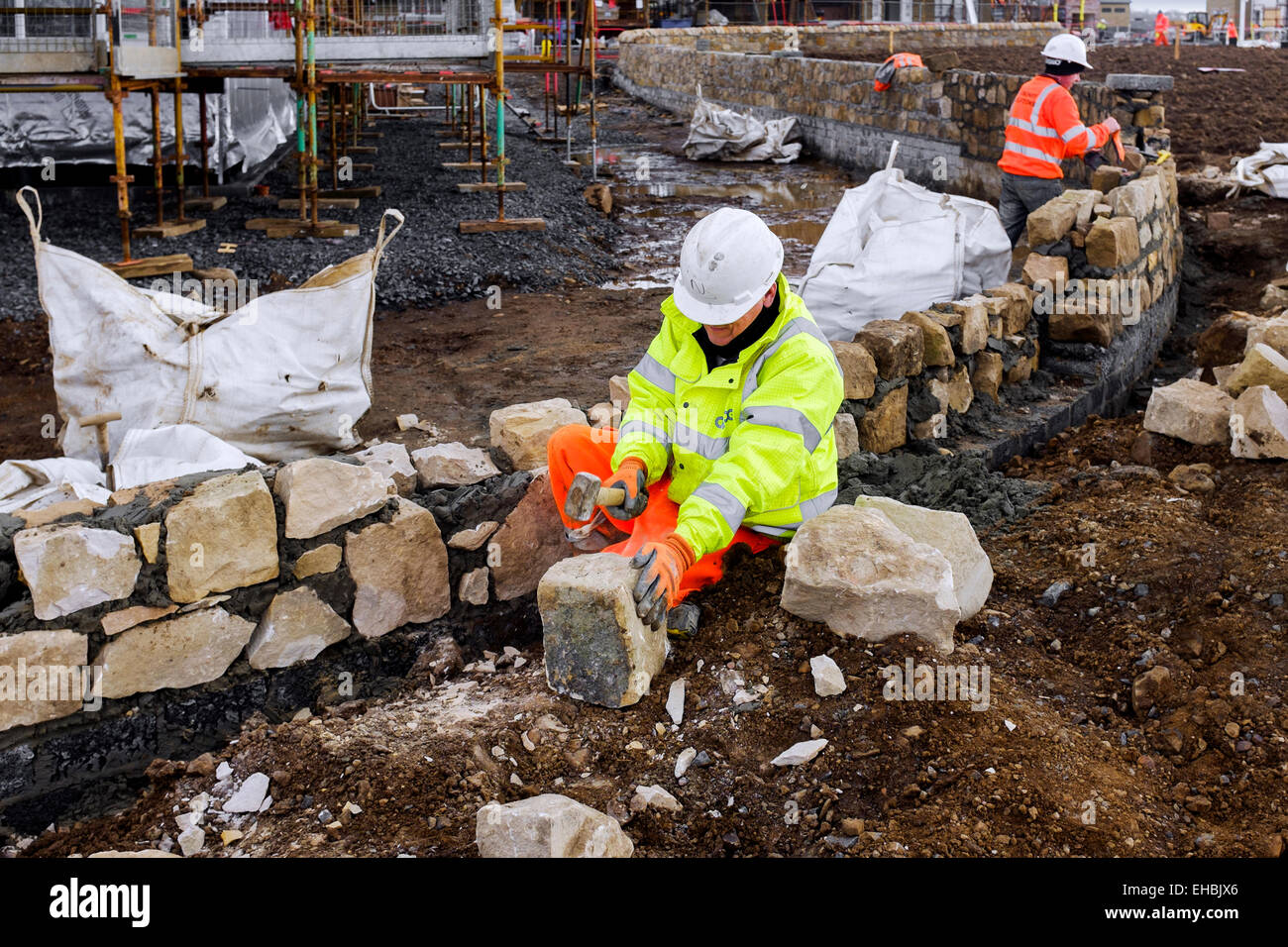Maître maçon construction d'un mur décoratif en grès de bloom sur une nouvelle construction housing estate, Troon, Ayrshire, Scotland Banque D'Images