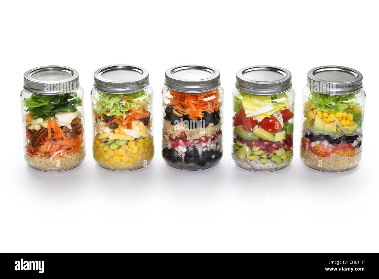 Salade de légumes maison dans un bocal en verre sur fond blanc Banque D'Images