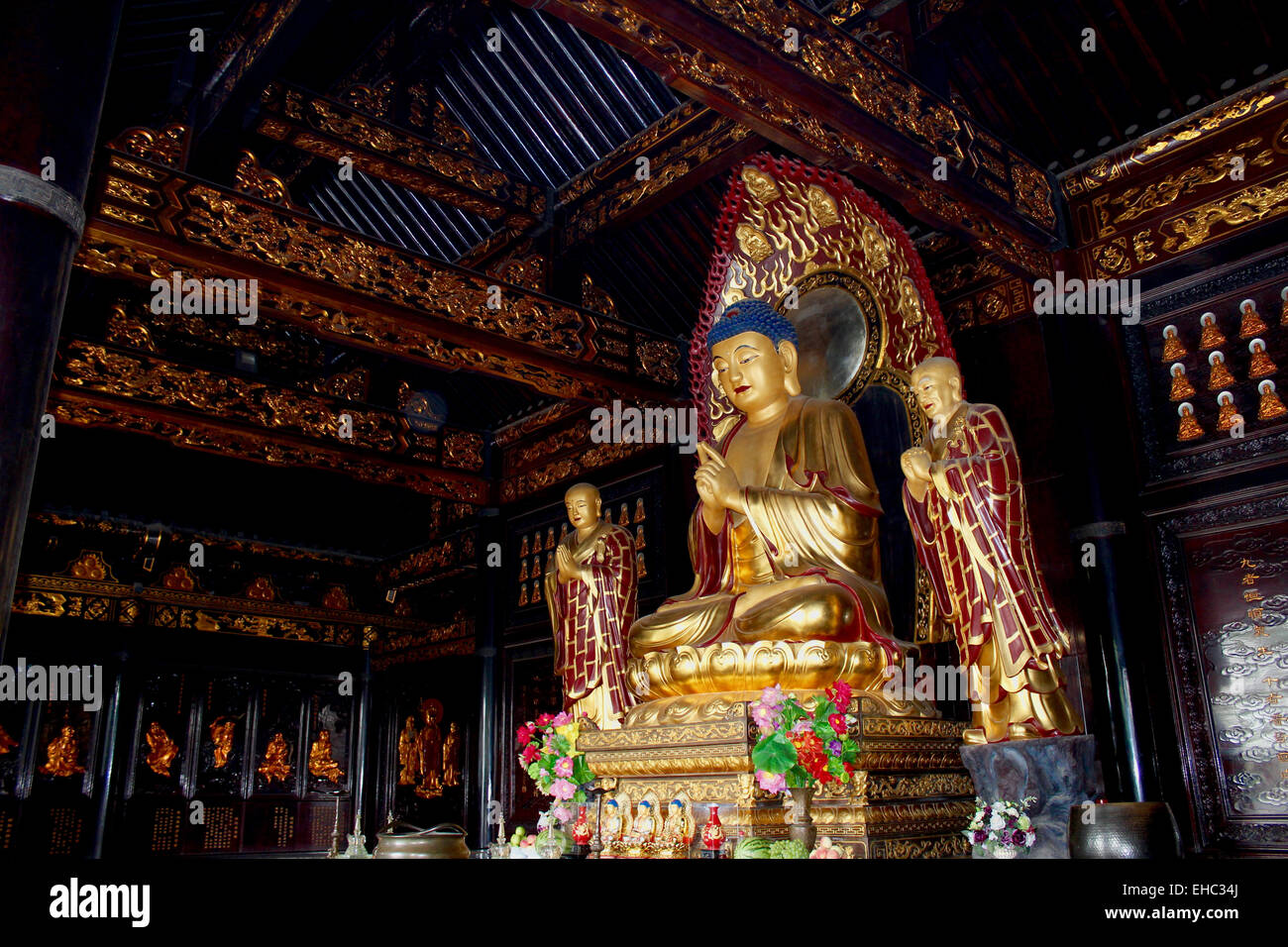 Photographie d'un Bouddha en or entouré de centaines de petits Bouddhas dans le temple de la Grande Pagode de l'Oie Sauvage, Xi'an. Banque D'Images