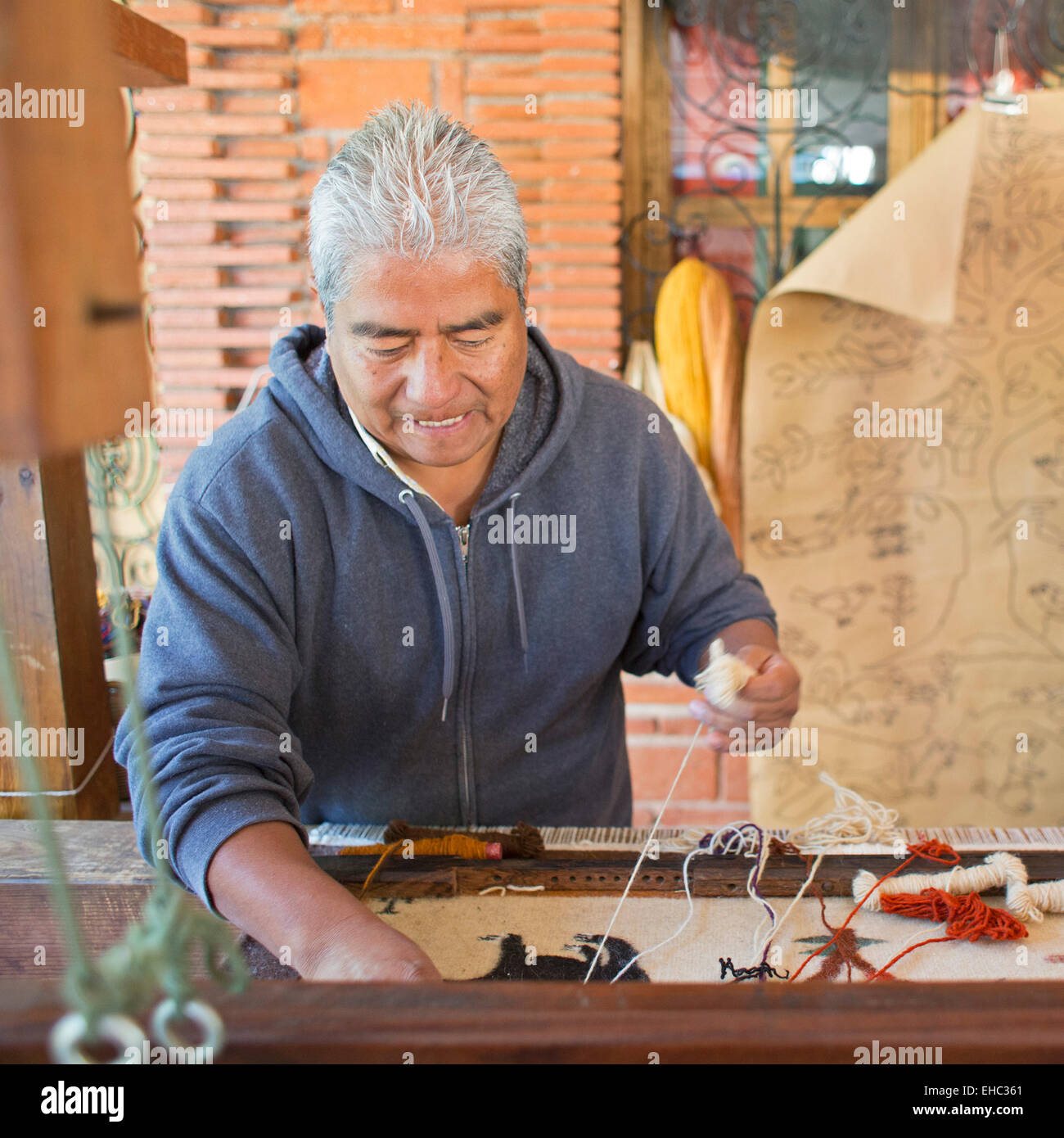 Teotitlán del Valle, Oaxaca, Mexique - Jerónimo Vásquez Gutiérrez démontre au tissage de tapis 'Le bug dans l'atelier des tapis. Banque D'Images