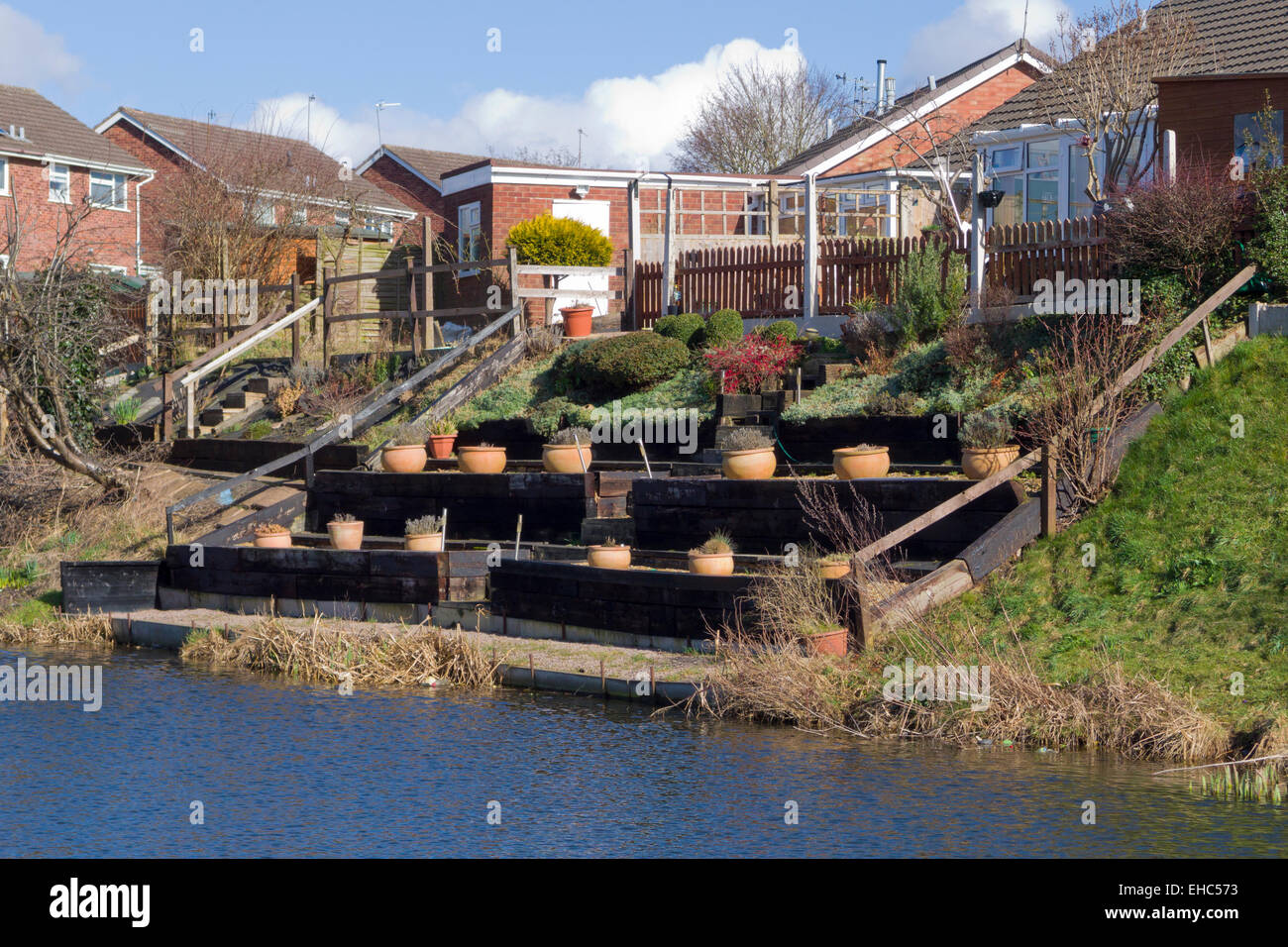 Le terrassement d'un jardin en pente à côté d'un canal, UK Banque D'Images