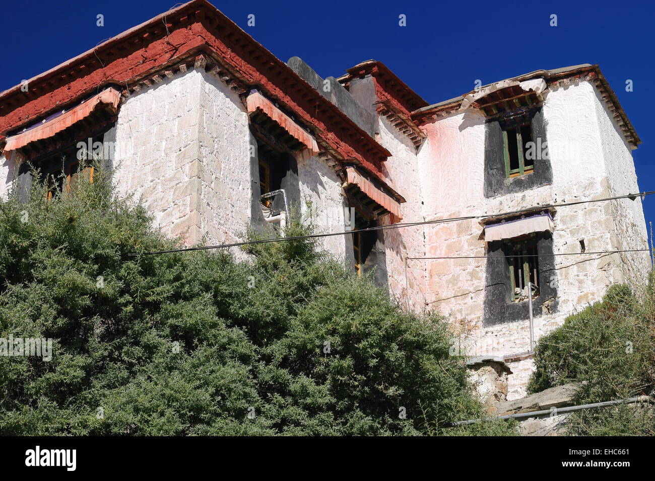 Fenêtres en bois coloriste sous le tissu pvc sur les murs blancs-frotte sur le rez-de-chaussée de l'Drepung-Rice Heap monast Banque D'Images