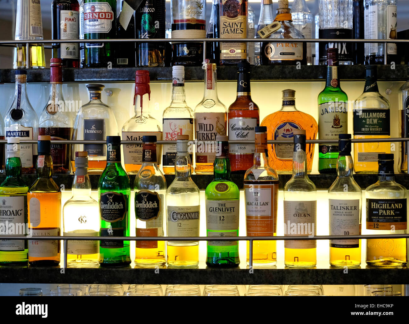 Sélection de whiskies et autres spiritueux Alcool sur une tablette en verre éclairée Banque D'Images