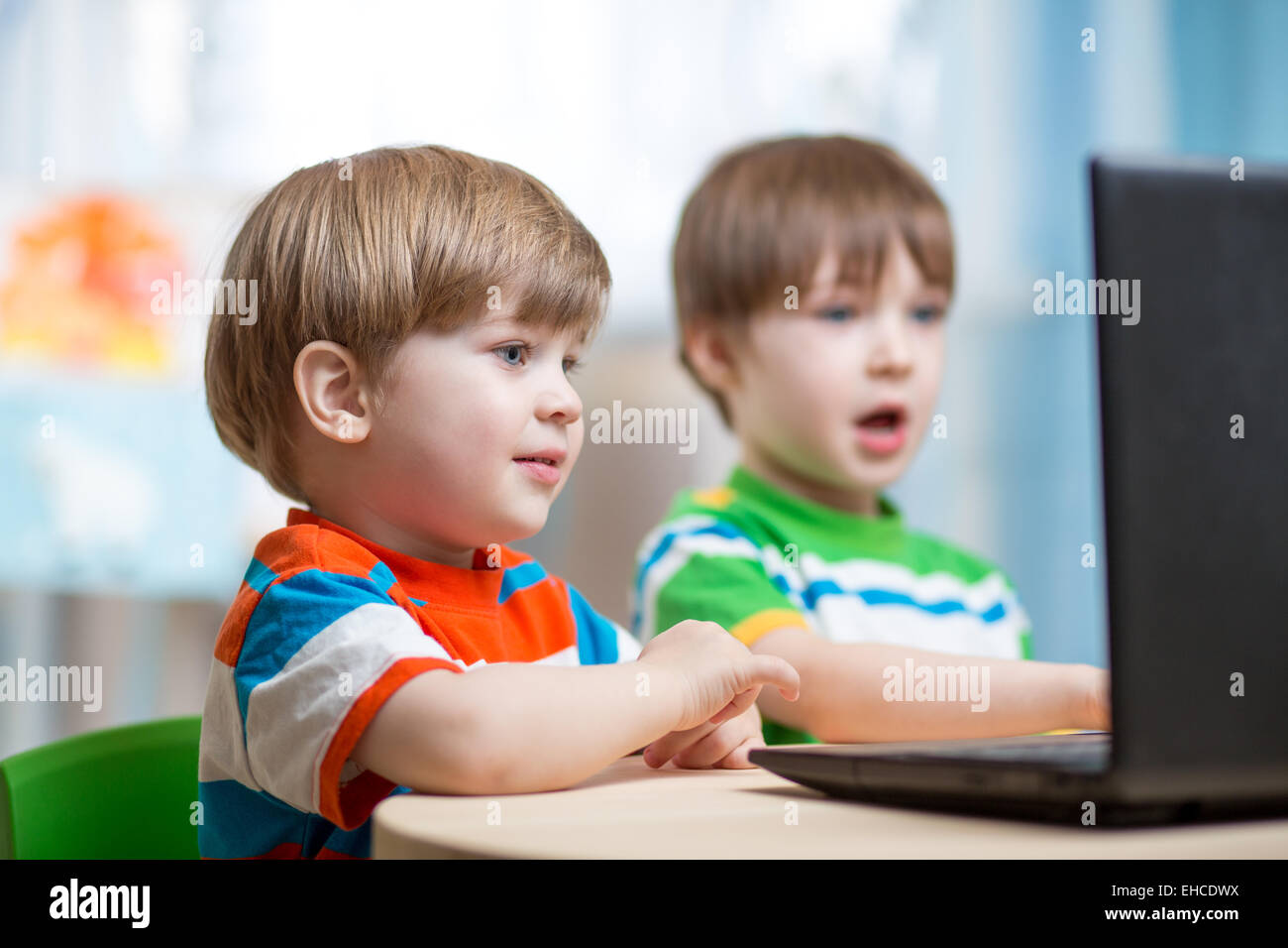 Heureux les enfants qui travaillent à l'ordinateur portable Banque D'Images