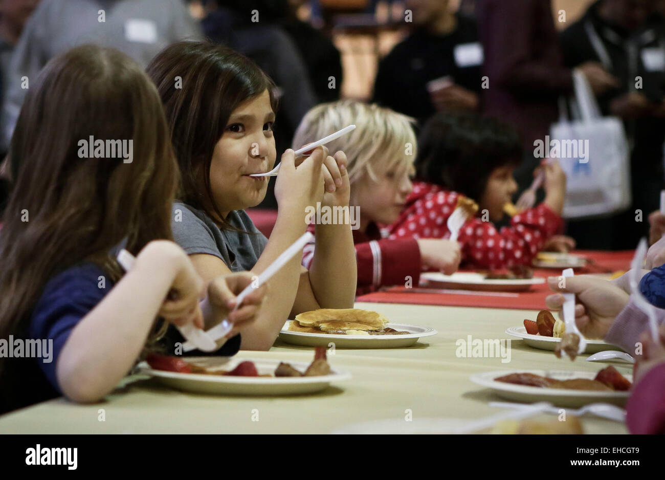 Vancouver, Canada. Mar 11, 2015. Les enfants bénéficient de leur nourriture pendant l'événement déjeuner aux crêpes à Vancouver, Canada, le 11 mars 2015. Environ 450 enfants de la pauvreté ont été servi avec petit déjeuner pendant le 22e Petit déjeuner aux crêpes événement organisé par la société de projet KidSafe. L'événement visait à sensibiliser les enfants de la pauvreté. © Liang Sen/Xinhua/Alamy Live News Banque D'Images
