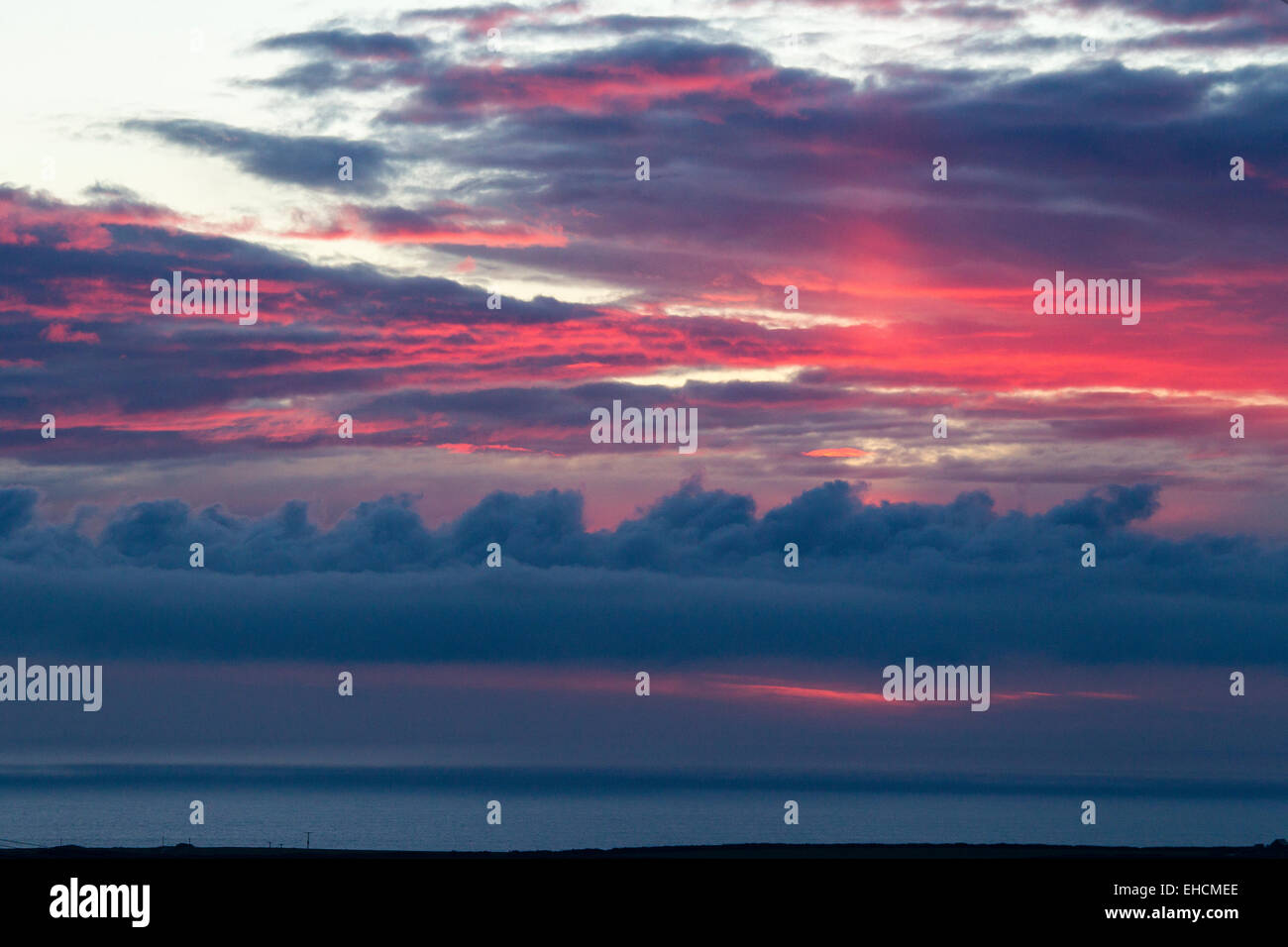 Ciel coucher soleil rouge avec alto cumulus au-dessus de Tintagel, Cornwall, United Kingdom Banque D'Images