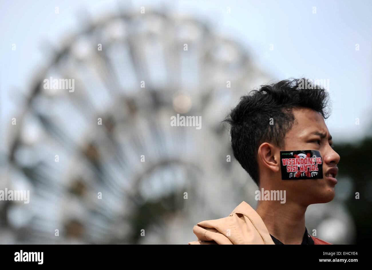 Jakarta, Indonésie. 12Th Mar, 2015. Une étudiante musulmane indonésienne avec un anti-ISIS (l'État islamique en Irak et en Syrie) autocollant sur son visage assiste à un rassemblement anti-ISIS à Jakarta, Indonésie, le 12 mars 2015. Ti'Kuncahya Crédit : B./Xinhua/Alamy Live News Banque D'Images