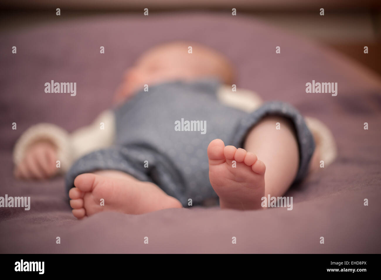 Sommeil de bébé nu sur un lit Banque D'Images