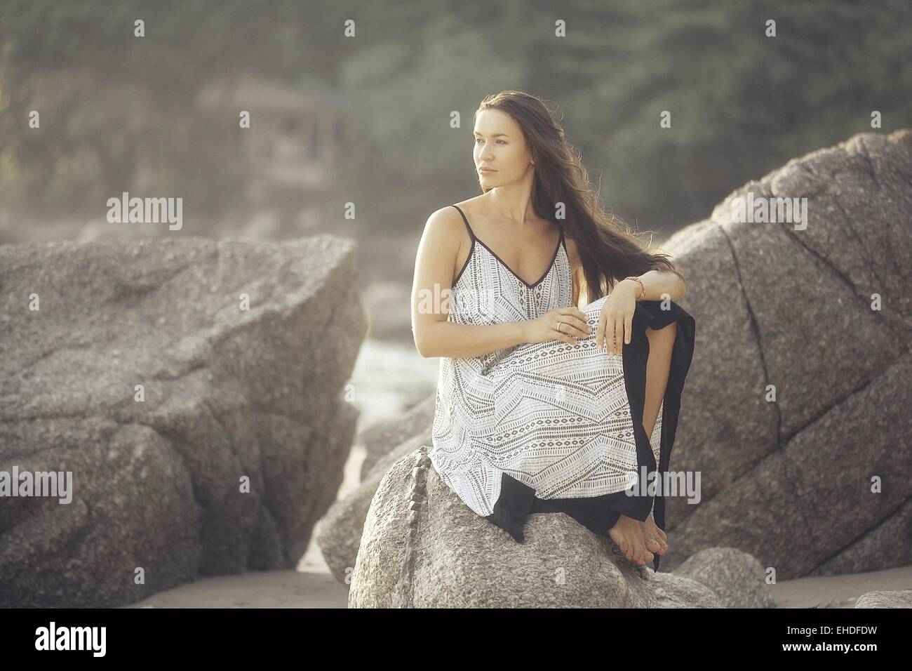 Jeune fille dans une robe d'été sur le modèle des roches Banque D'Images