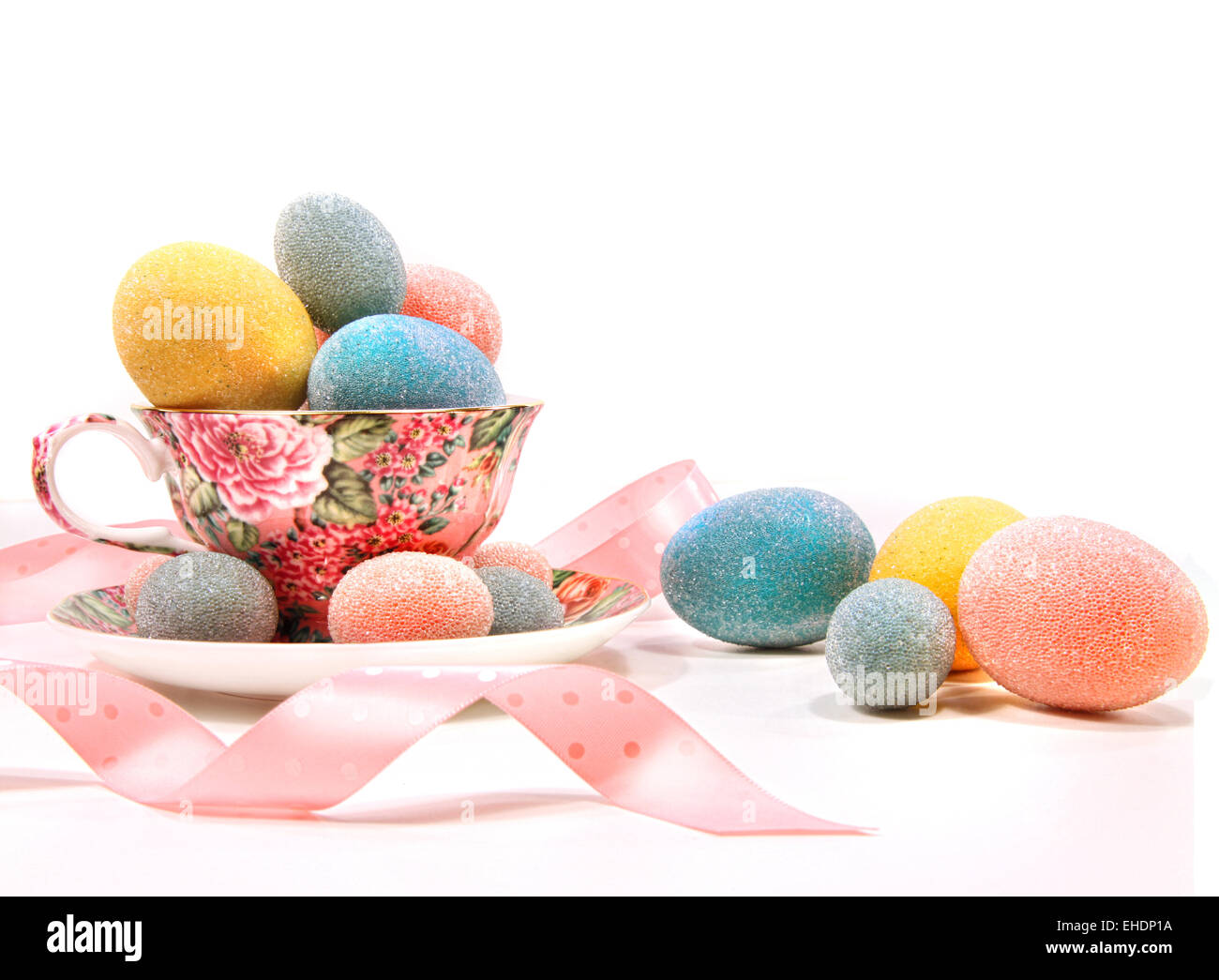 Les œufs de couleur vive en tasse de thé on white Banque D'Images