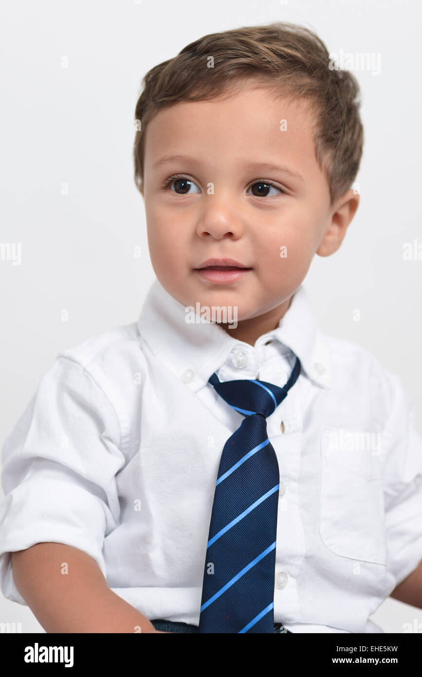 Deux ans cute boy tient une fleur et un animal en peluche posant isolé dans un fond blanc. Banque D'Images