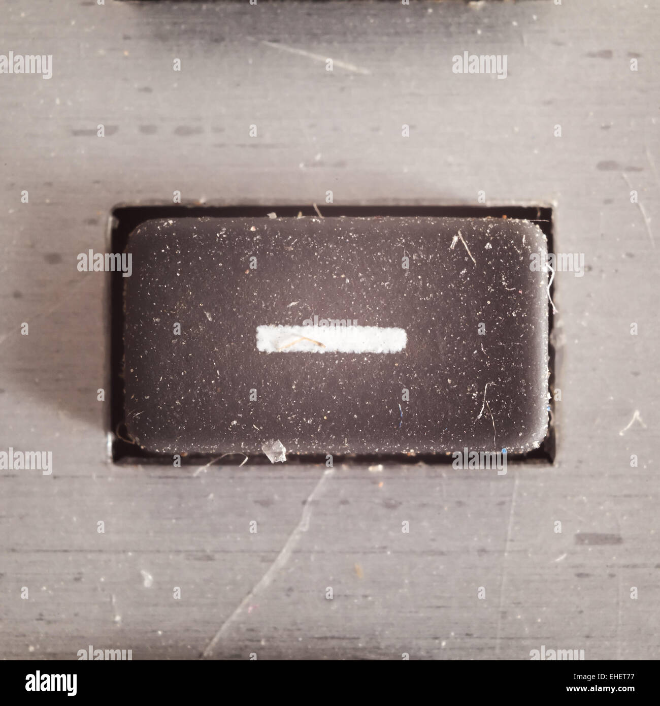 Ancien bouton caoutchouté sale et poussiéreux avec symbole mathématique écrit sur elle, partie d'une ancienne calculatrice. Banque D'Images