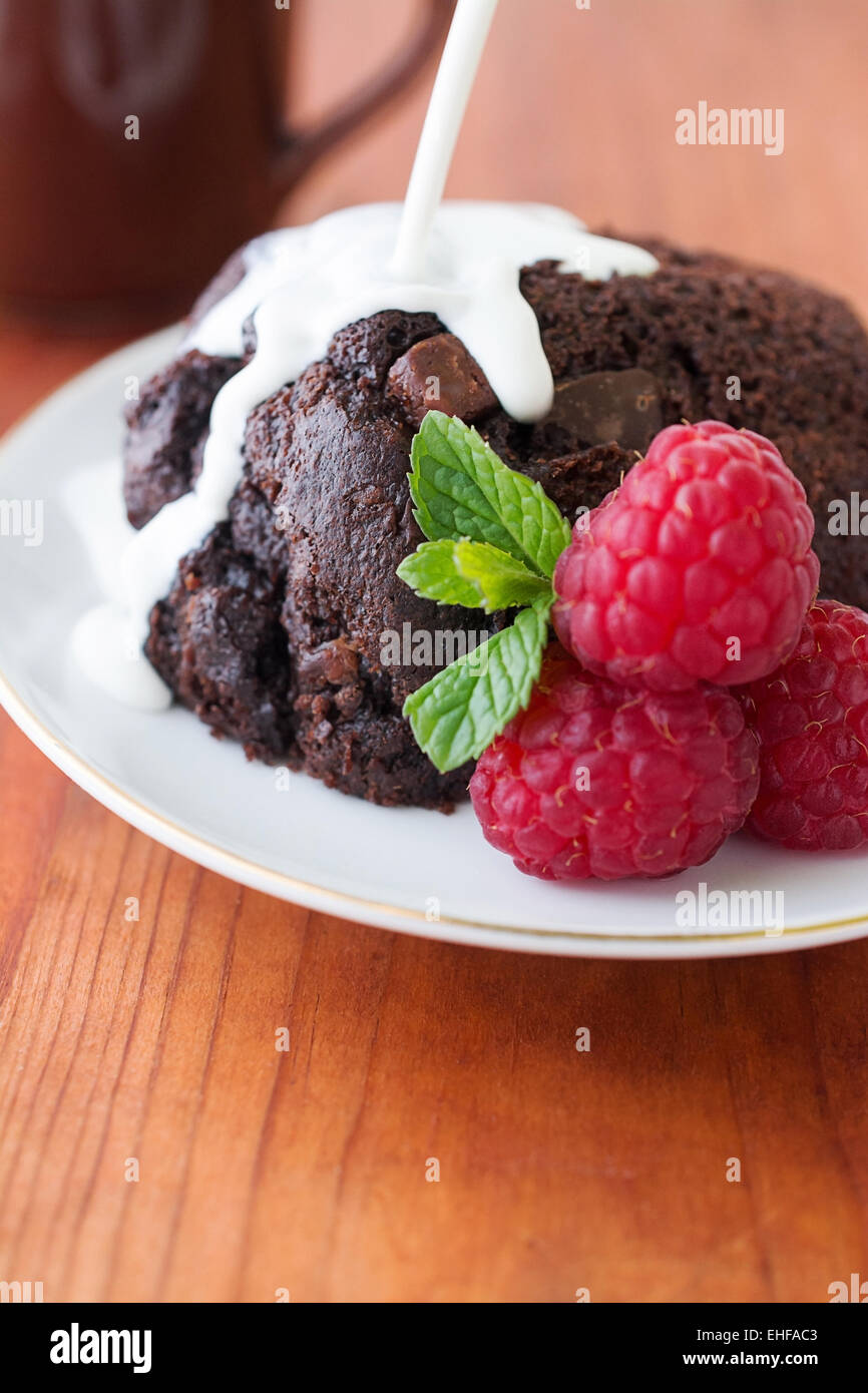 Selective focus sur un muffin au chocolat avec des framboises et de la crème, de place pour le texte, Banque D'Images