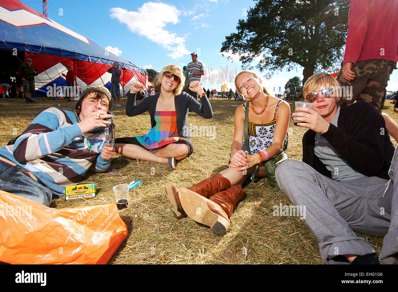 Groupe d'amis s'assit sur l'herbe à la Glade Festival 2008. Banque D'Images