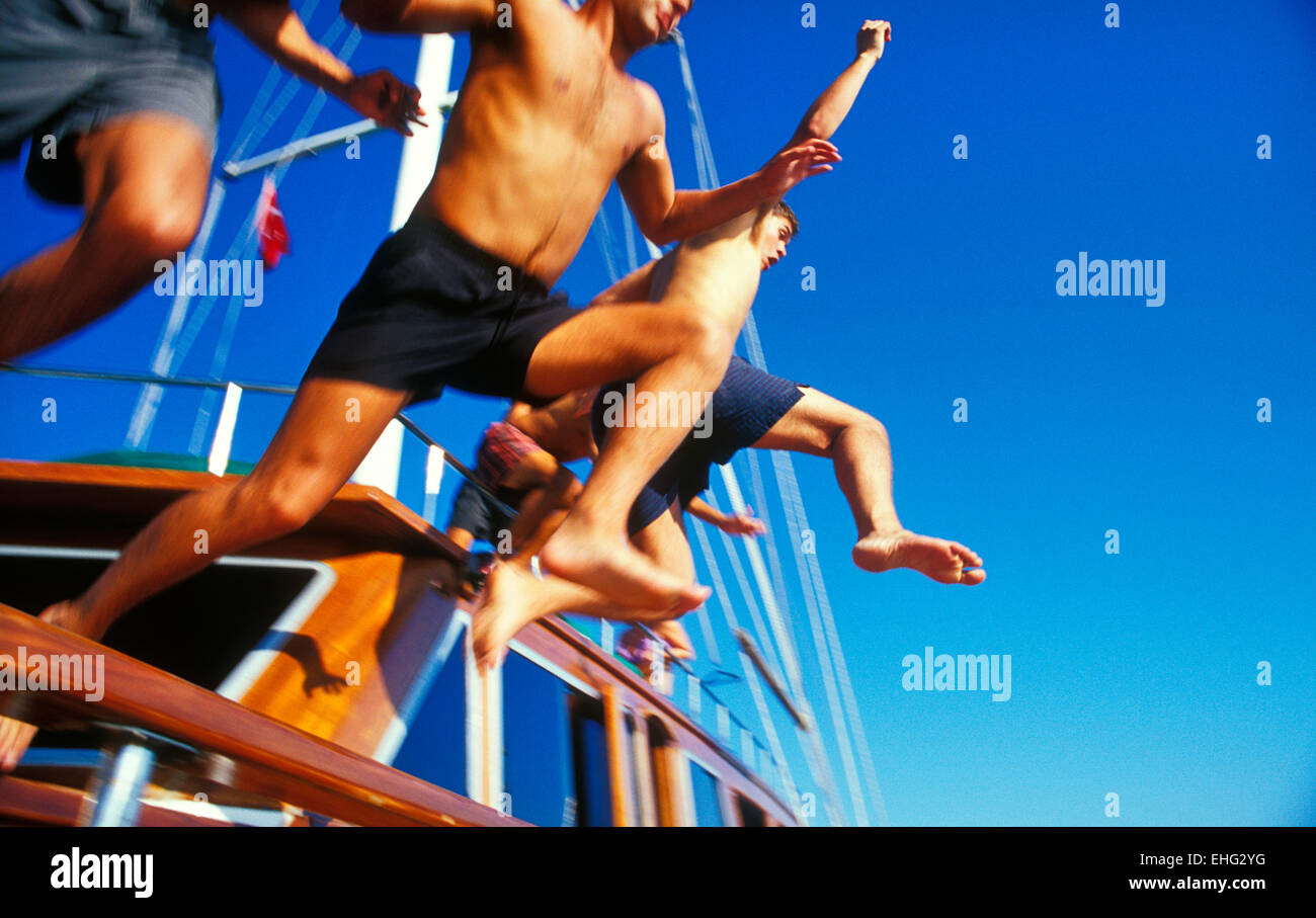 Groupe de garçons sauter d'un bateau ibn Ibiza. Banque D'Images