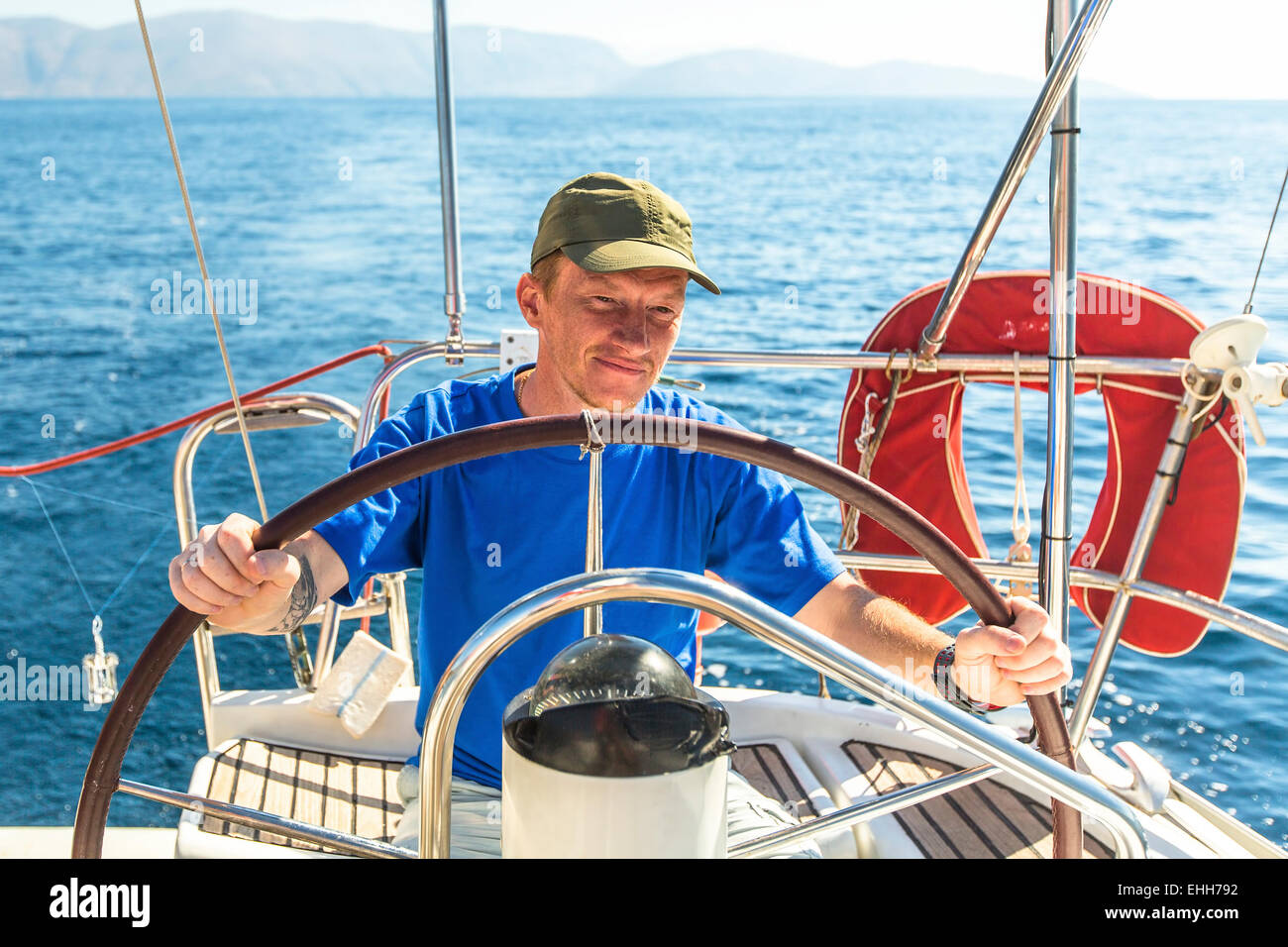 Jeune homme skipper à la barre contrôle yacht à voile Photo Stock - Alamy