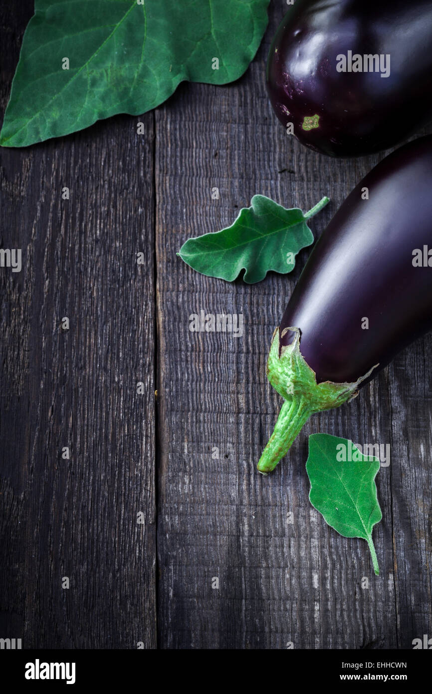 Aubergines fraîches savoureuses sur la vieille table de bois, chasse d'automne. Banque D'Images