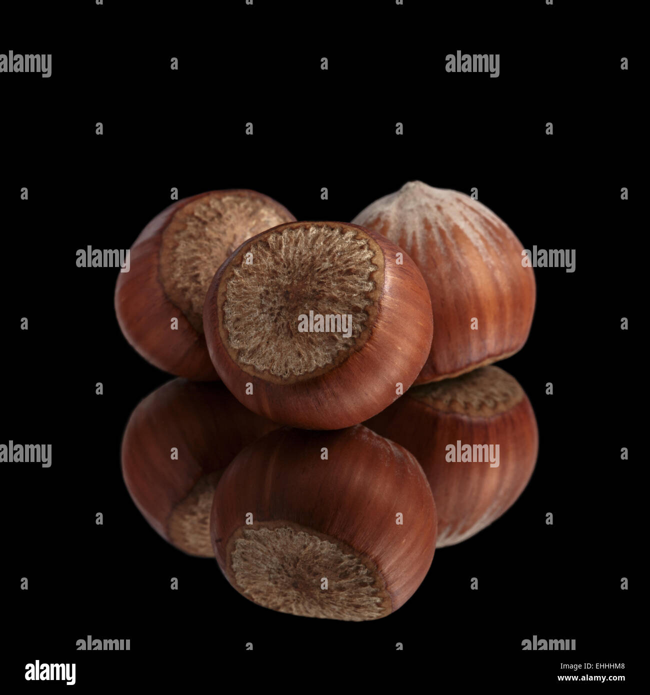 Trois noisettes sur miroir, isolé Banque D'Images