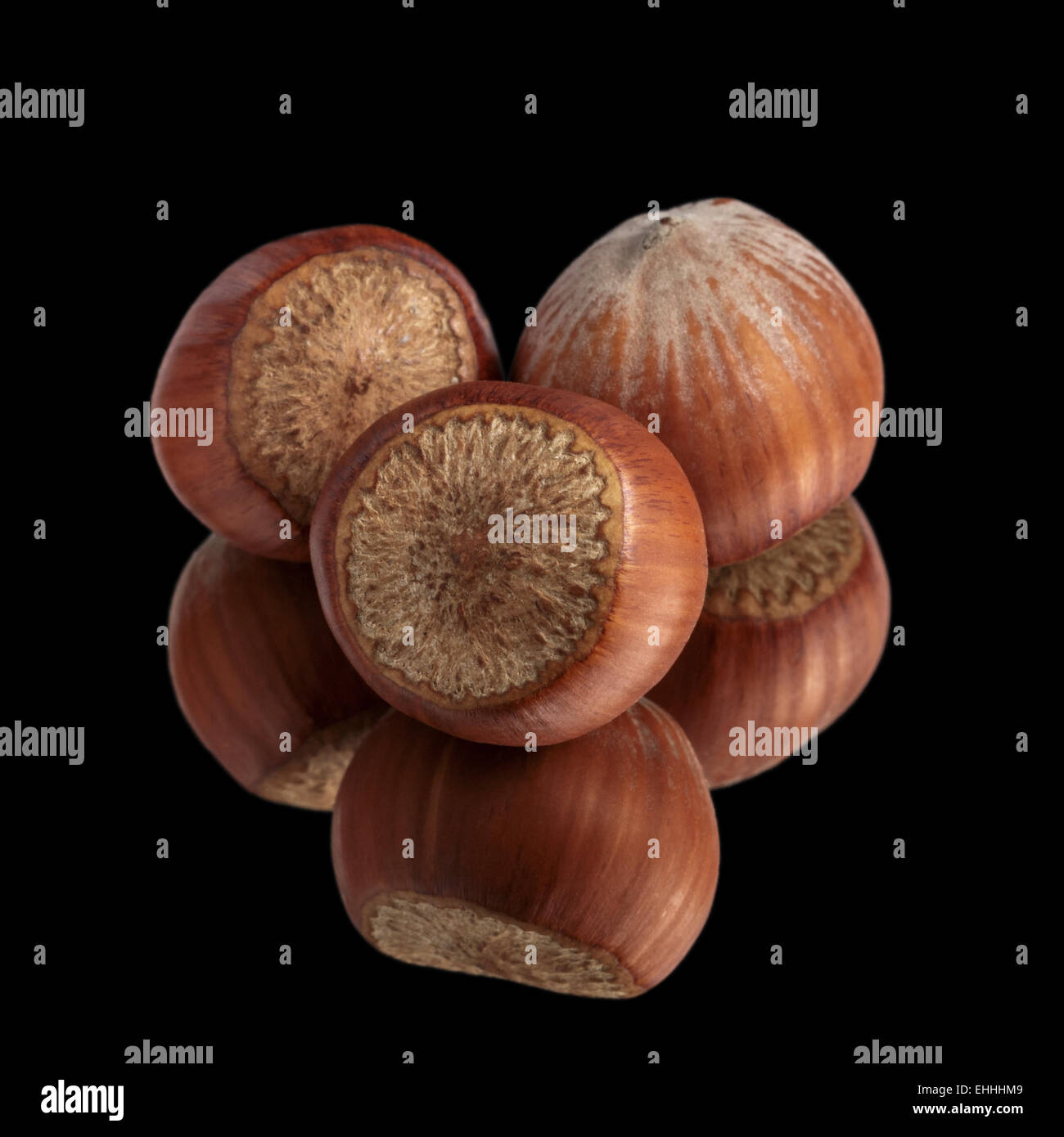 Trois noisettes sur miroir, isolé Banque D'Images