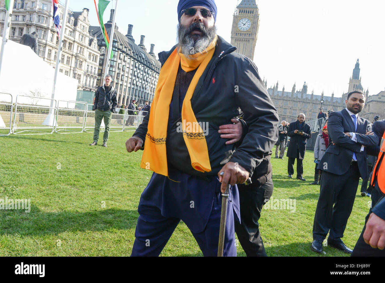 La place du parlement, Londres, Royaume-Uni. 14 mars 2015. Le dirigeant d'une manifestante est escorté hors de la place. Statue en bronze du Mahatma Gandhi par sculpteur britannique Philip Jackson, est dévoilée à la place du Parlement. Crédit : Matthieu Chattle/Alamy Live News Banque D'Images