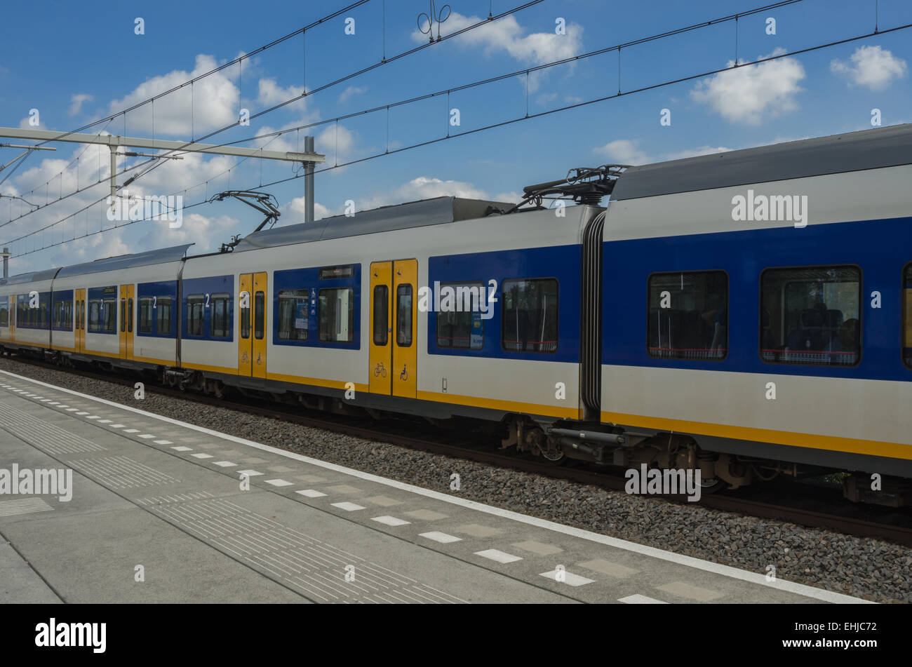 Bleu, blanc et jaune voitures de train transporter des passagers le long des chemins de fer néerlandais Banque D'Images