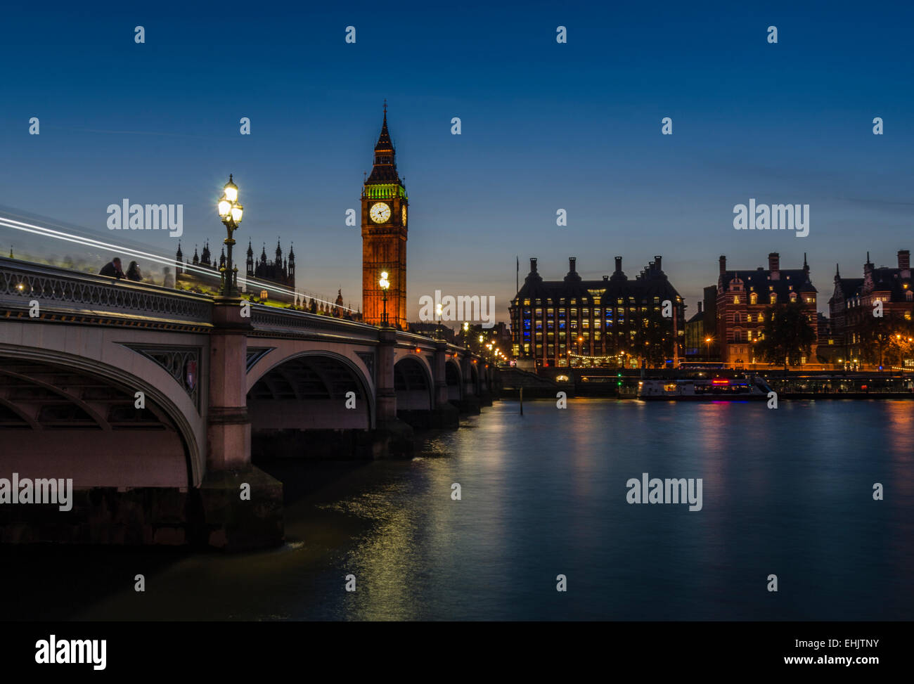 Big Ben et London's skyline sont illuminés de nuit et se reflètent dans la Tamise, que le trafic passe sur le pont de Westminster . Banque D'Images