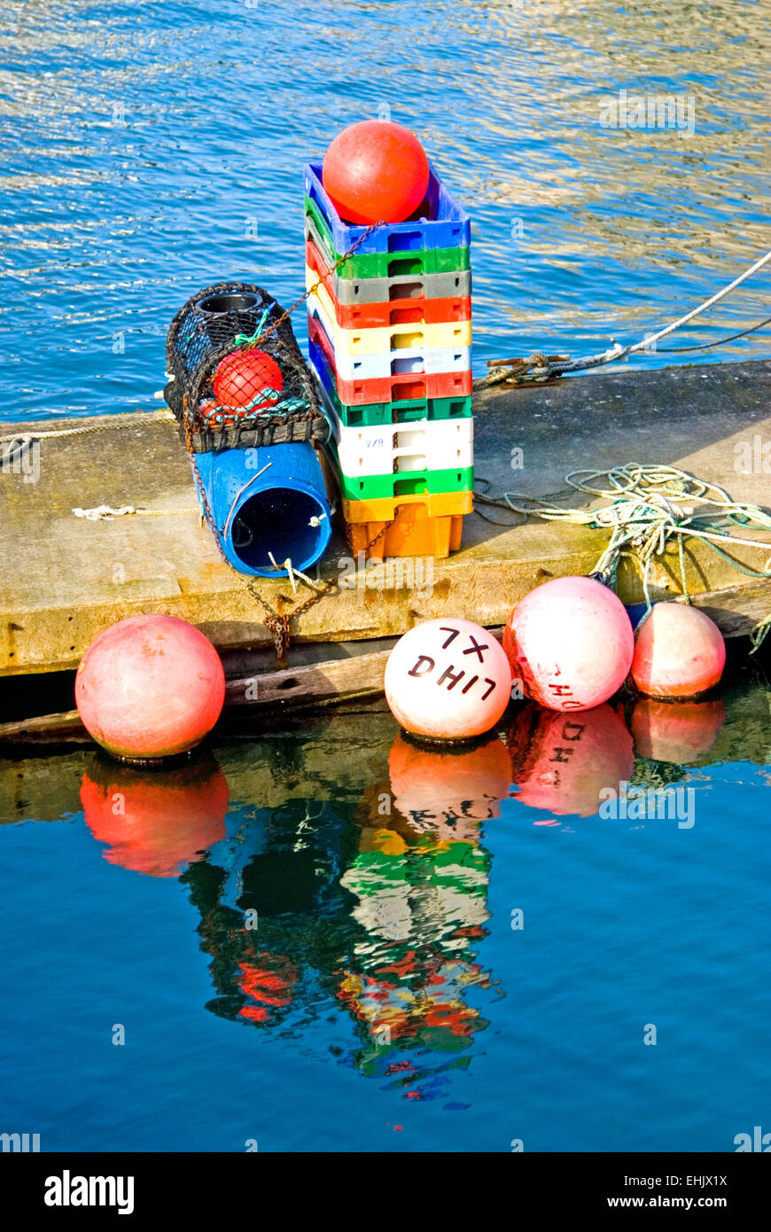 Les boîtes en plastique coloré et des bouées utilisées par les équipes de pêche se tenir sur une plate-forme flottante Banque D'Images