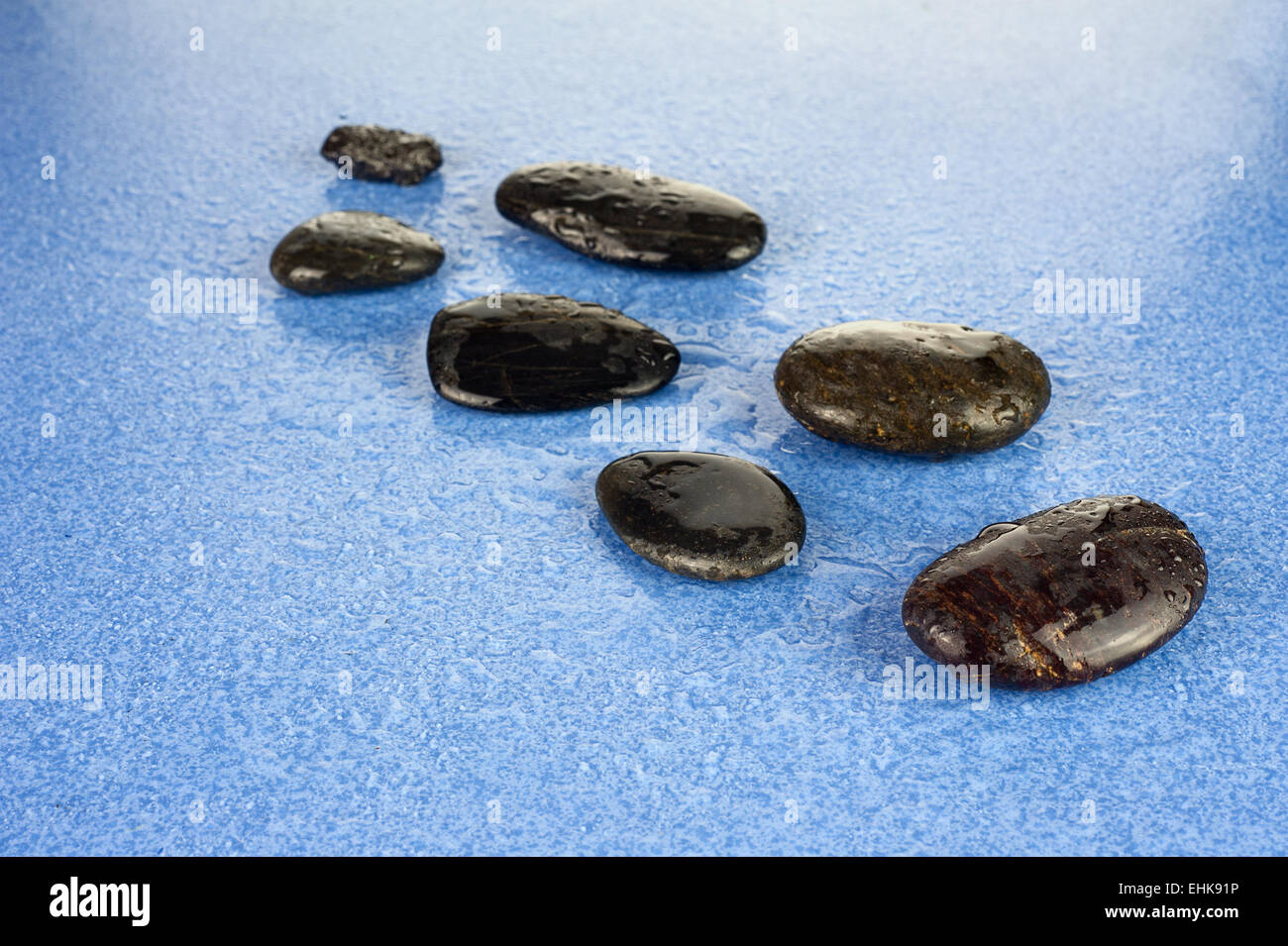 Cailloux Zen. Black spa pierres sur fond bleu. Banque D'Images