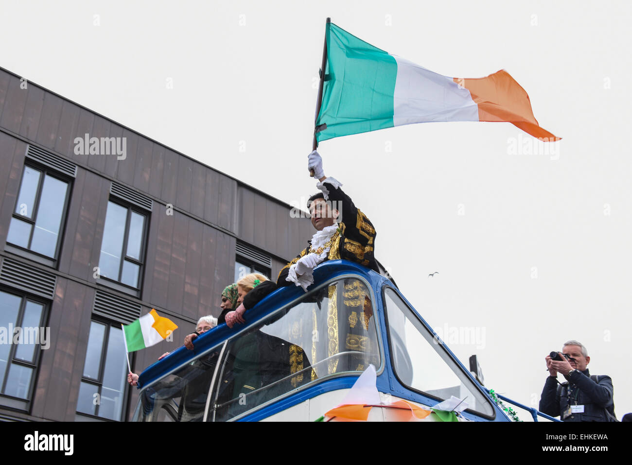 Birmingham, Maire de tient le drapeau irlandais de haut d'un bus au cours de la Birmingham le jour de rue Patrick parade. Banque D'Images