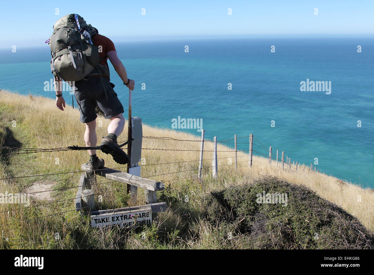 L'homme grimpe clôture sur la péninsule de Banks, sentier de randonnée Piste, Nouvelle-Zélande, île du Sud Banque D'Images