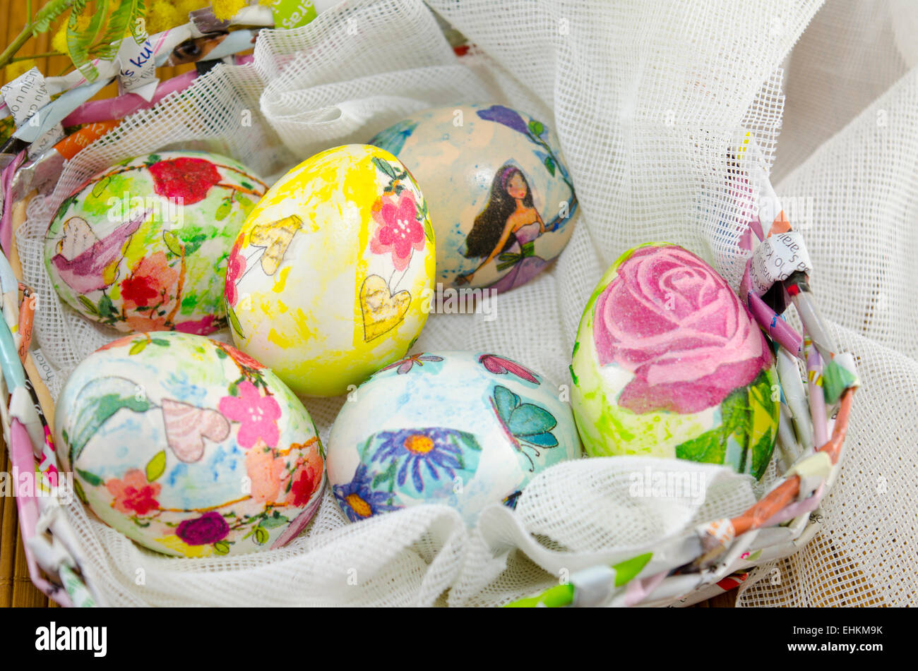 Bande d'œufs de Pâques colorés à la main dans un panier d'oeufs de papier fait main Banque D'Images