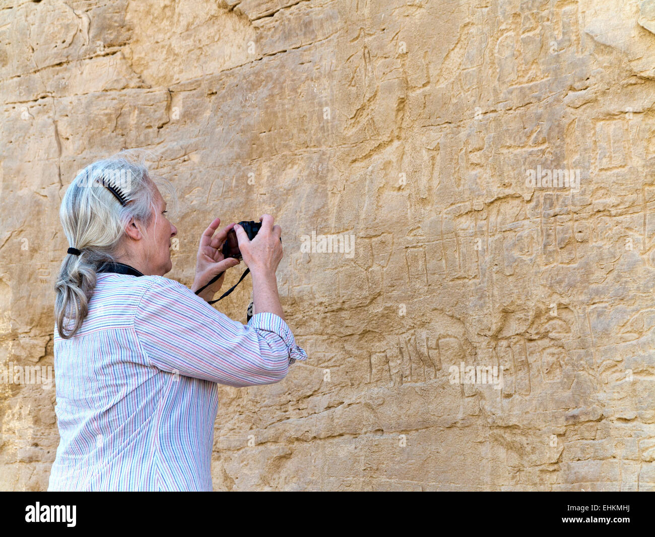Photographier des femmes à l'art Rock Rock vautour à l'entrée de l'Oued Hellal, el Kab, ancienne Nekheb dans l'est désert, Egypte Banque D'Images