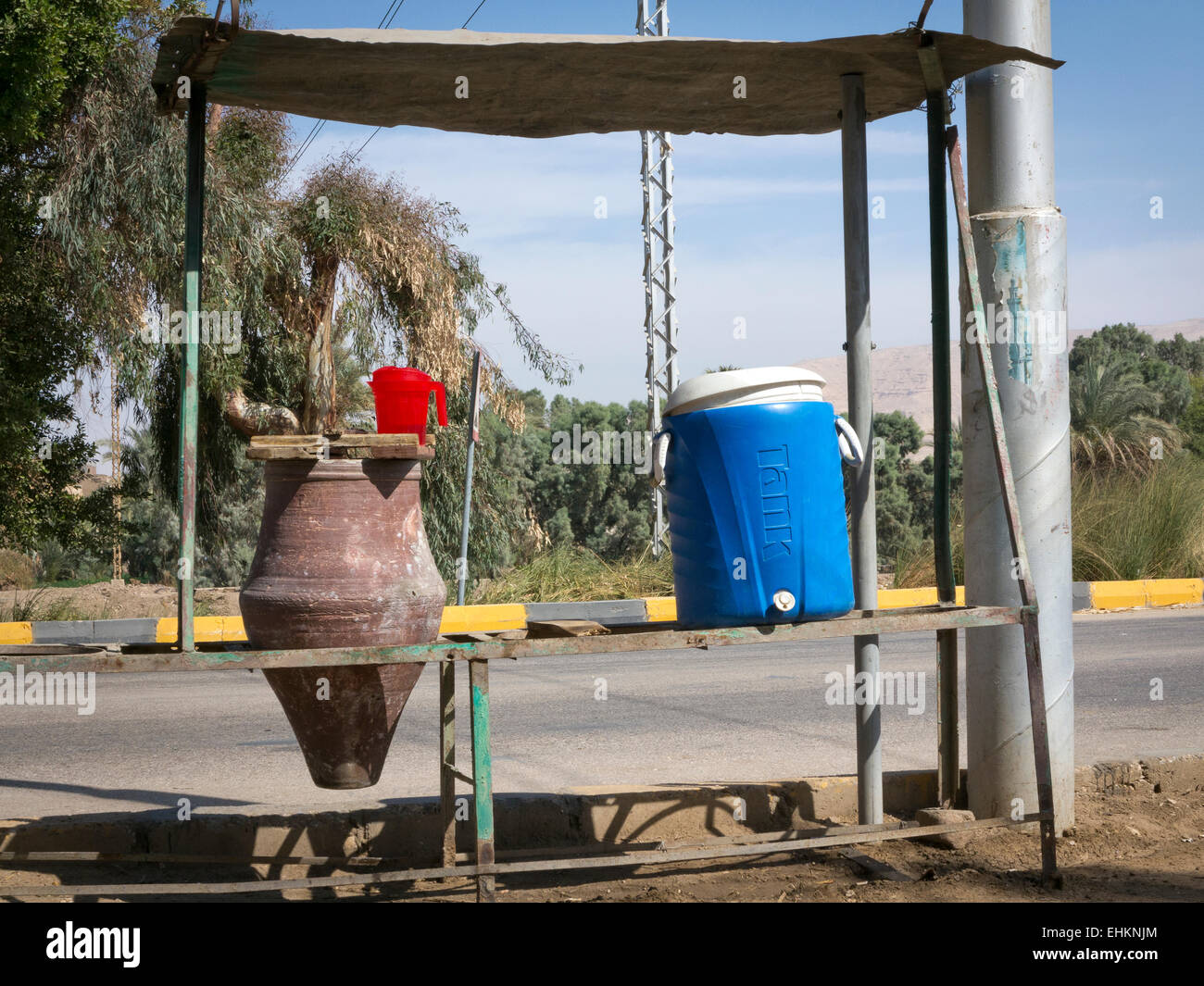 1 et 1 de la poterie en plastique bleu de l'eau potable publique transporteurs sur la route, sous un auvent ombragé Afrique Egypte Banque D'Images