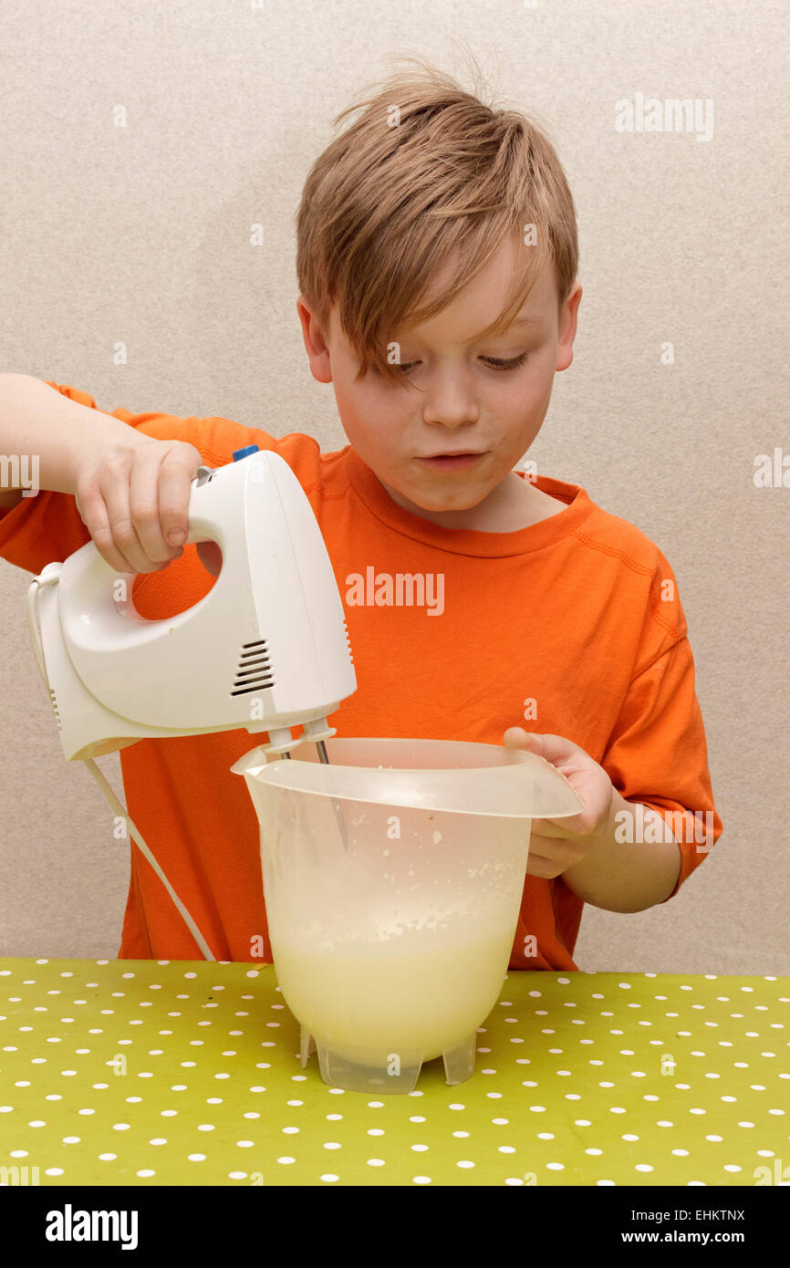Jeune garçon faisant la crème fouettée Banque D'Images