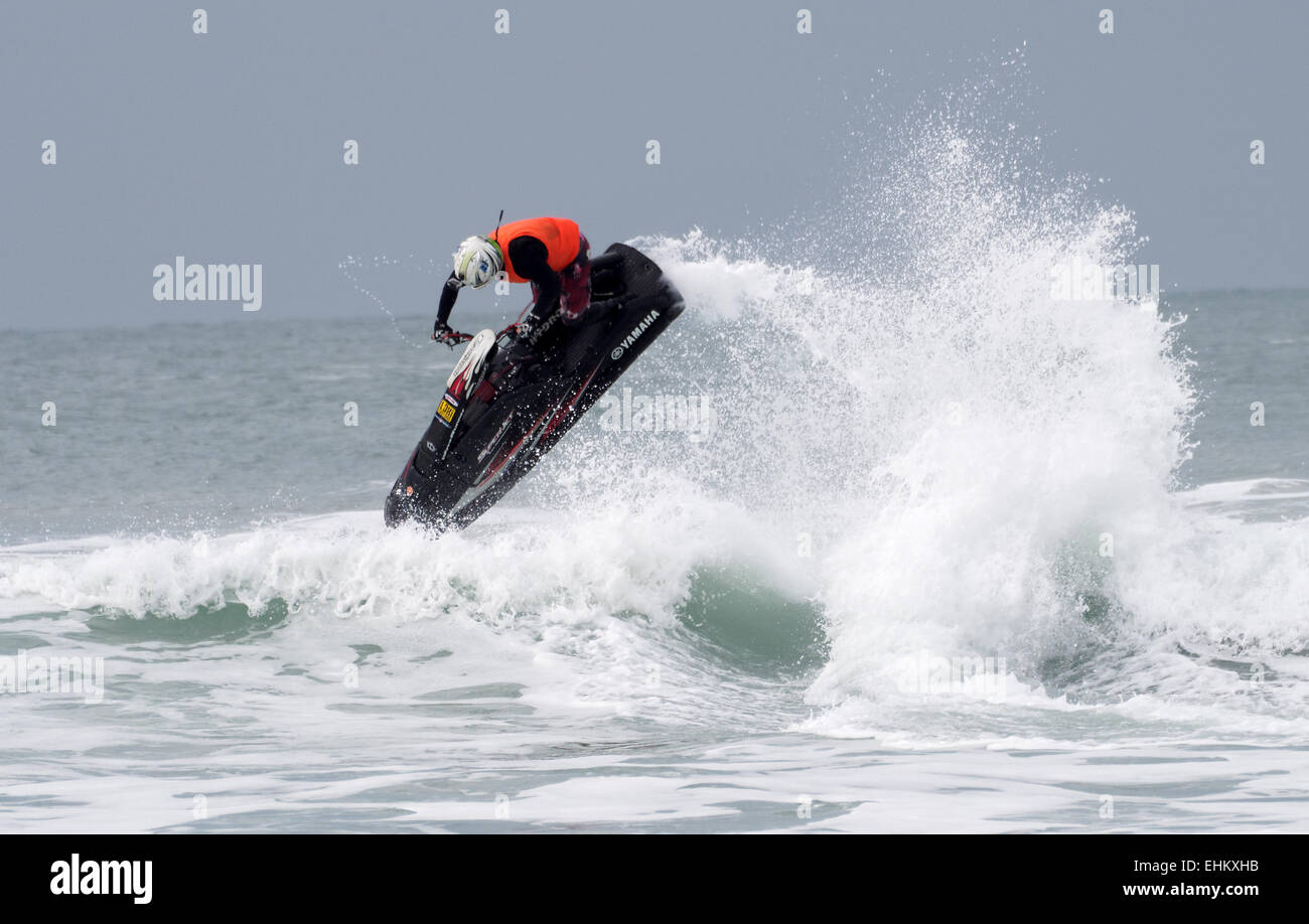 Homme jet ski concurrent exécute l'action de l'antenne se déplace dans de grandes vagues déferlantes sur la plage de Fistral Newquay Banque D'Images