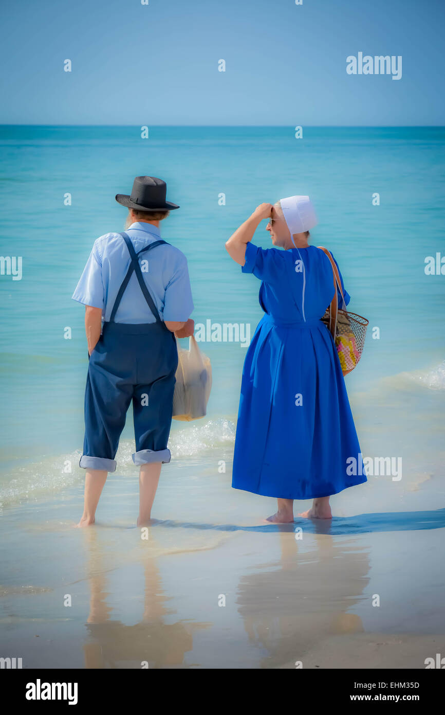 Un couple Amish, vêtus de leur mode traditionnel de la pagaie dans les eaux de surf à Siesta Key Beach à Sarasota, FL Banque D'Images