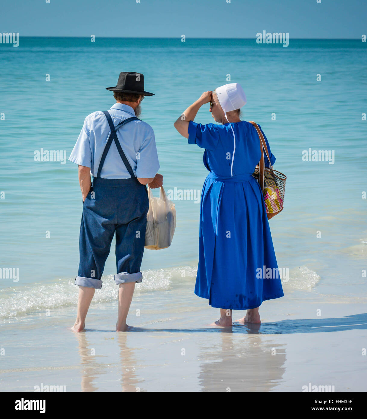 Un couple Amish, vêtus de leur mode traditionnel de la pagaie dans les eaux de surf à Siesta Key Beach à Sarasota, FL Banque D'Images