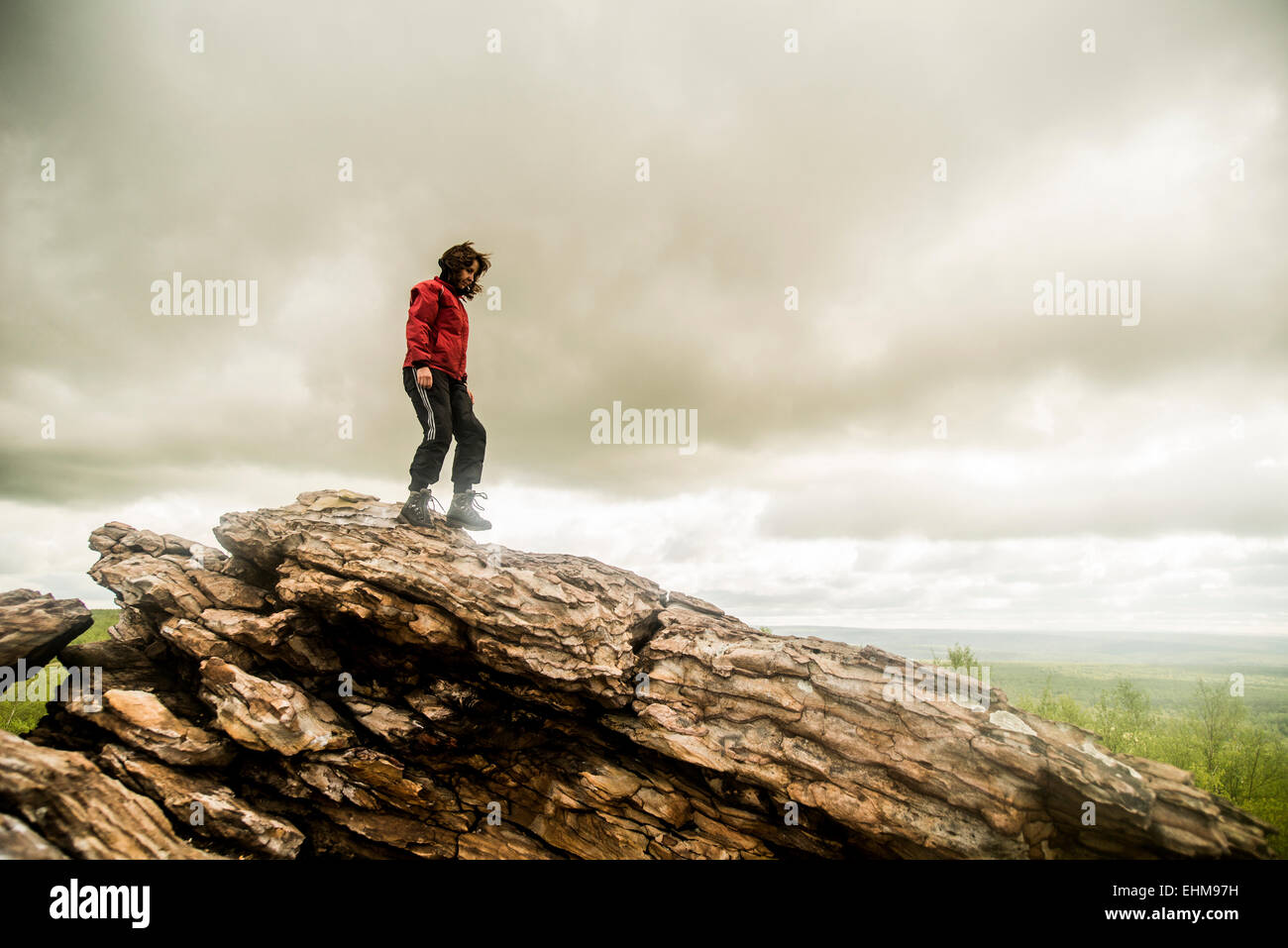 Caucasian woman climbing rock formation Banque D'Images