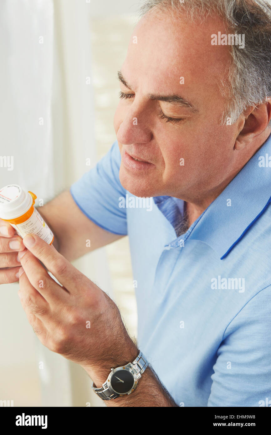 Hispanic man reading médicament de prescription bottle Banque D'Images