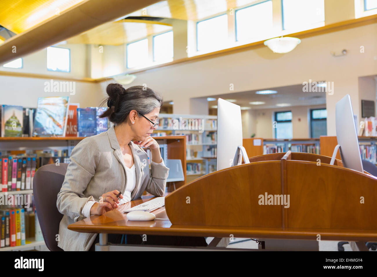 Older Caucasian woman using computer in library Banque D'Images