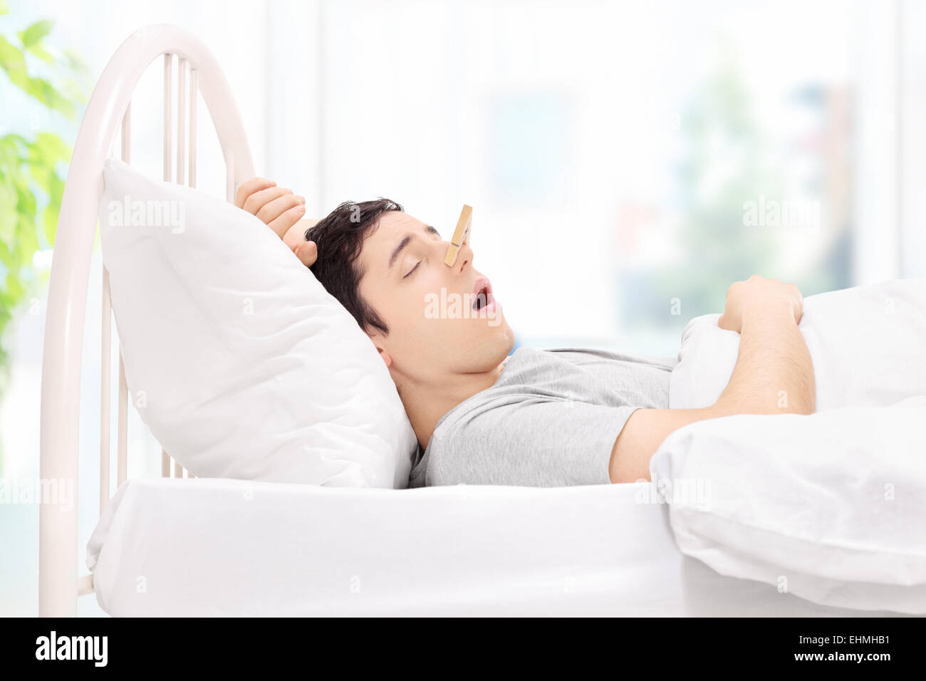 Dormir avec un homme clothespin sur son nez à la maison Banque D'Images