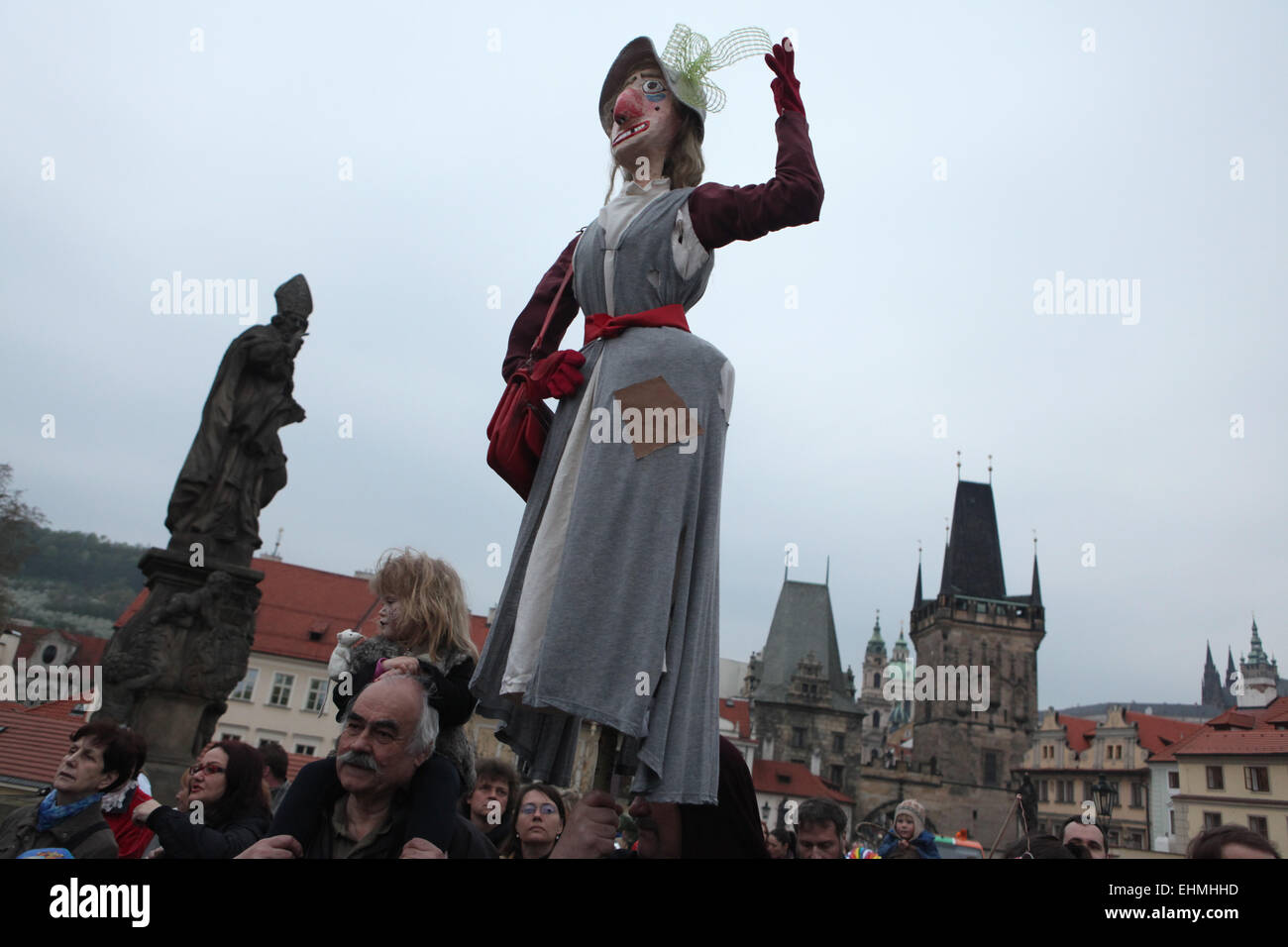 Les participants de la parade costumée à la Nuit des Sorcières portent une sorcière de paille sur le pont Charles à Prague, République tchèque. Banque D'Images