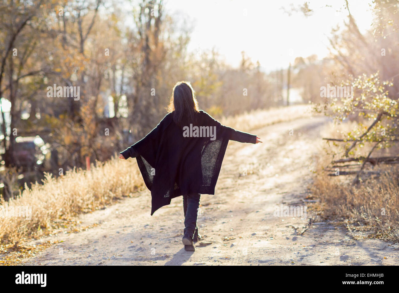 Older Hispanic woman walking on dirt path Banque D'Images