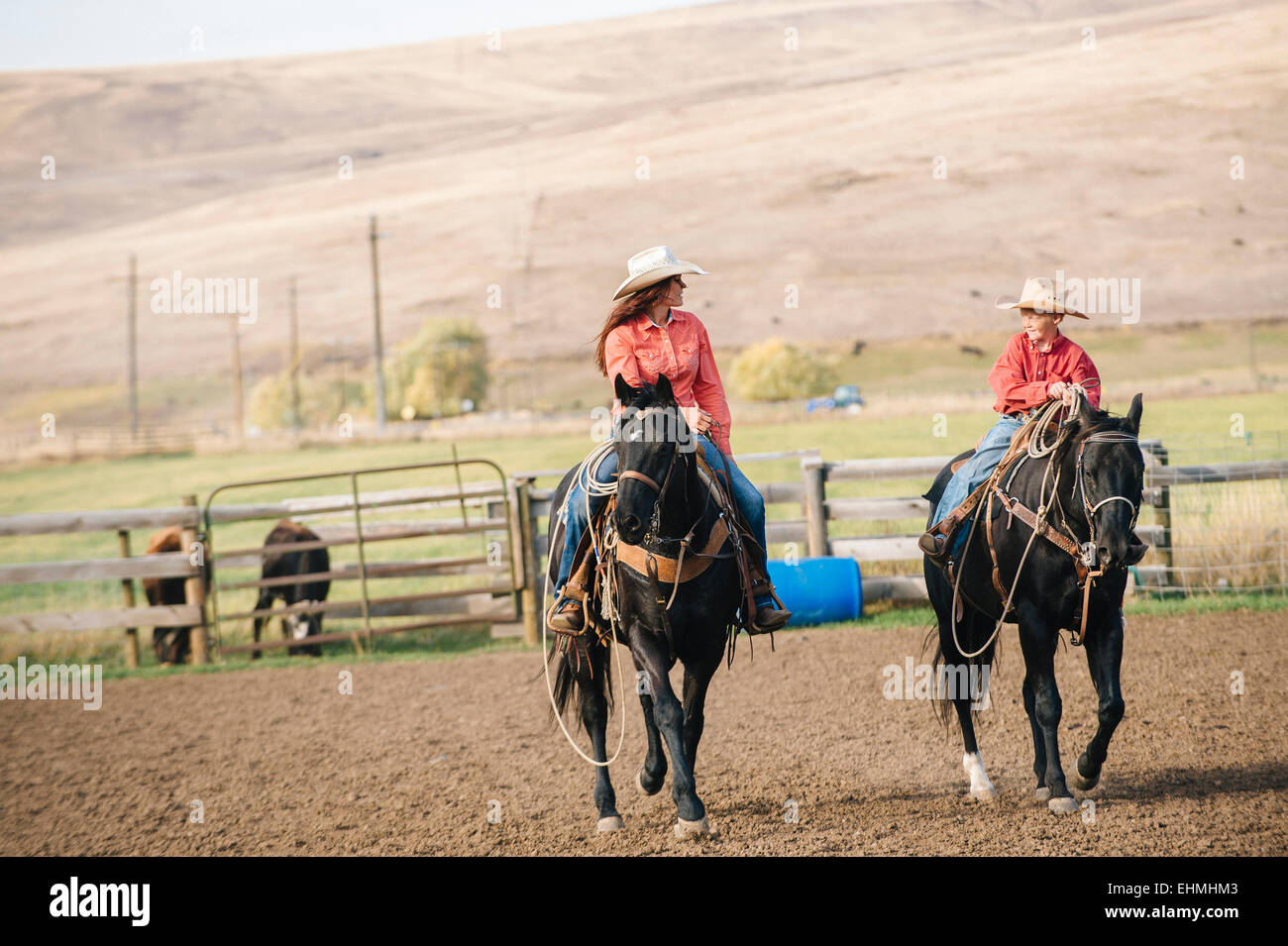 Caucasian mother and son riding horses ranch sur Banque D'Images