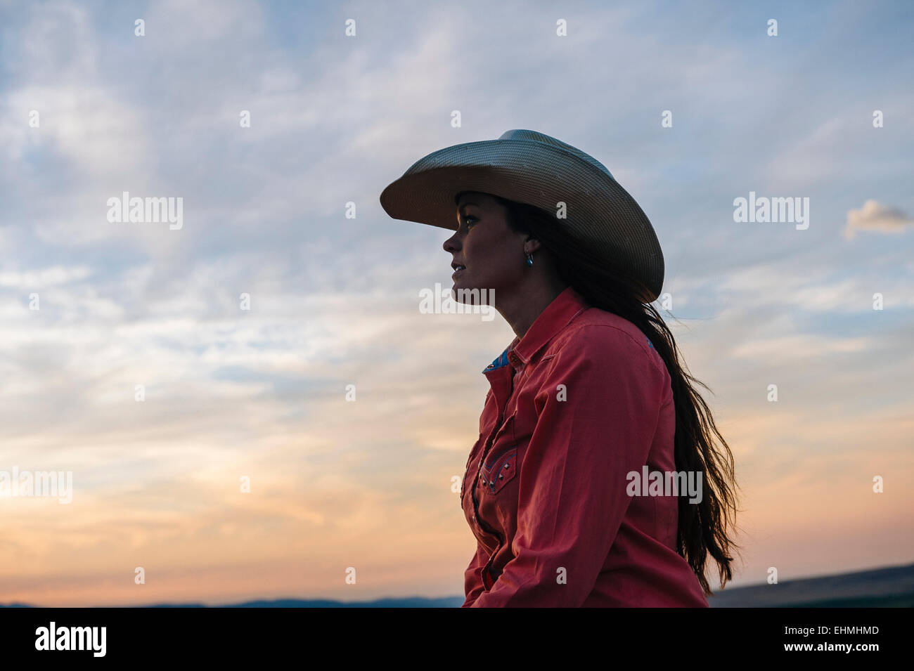 Caucasian woman sous Ciel de coucher du soleil Banque D'Images