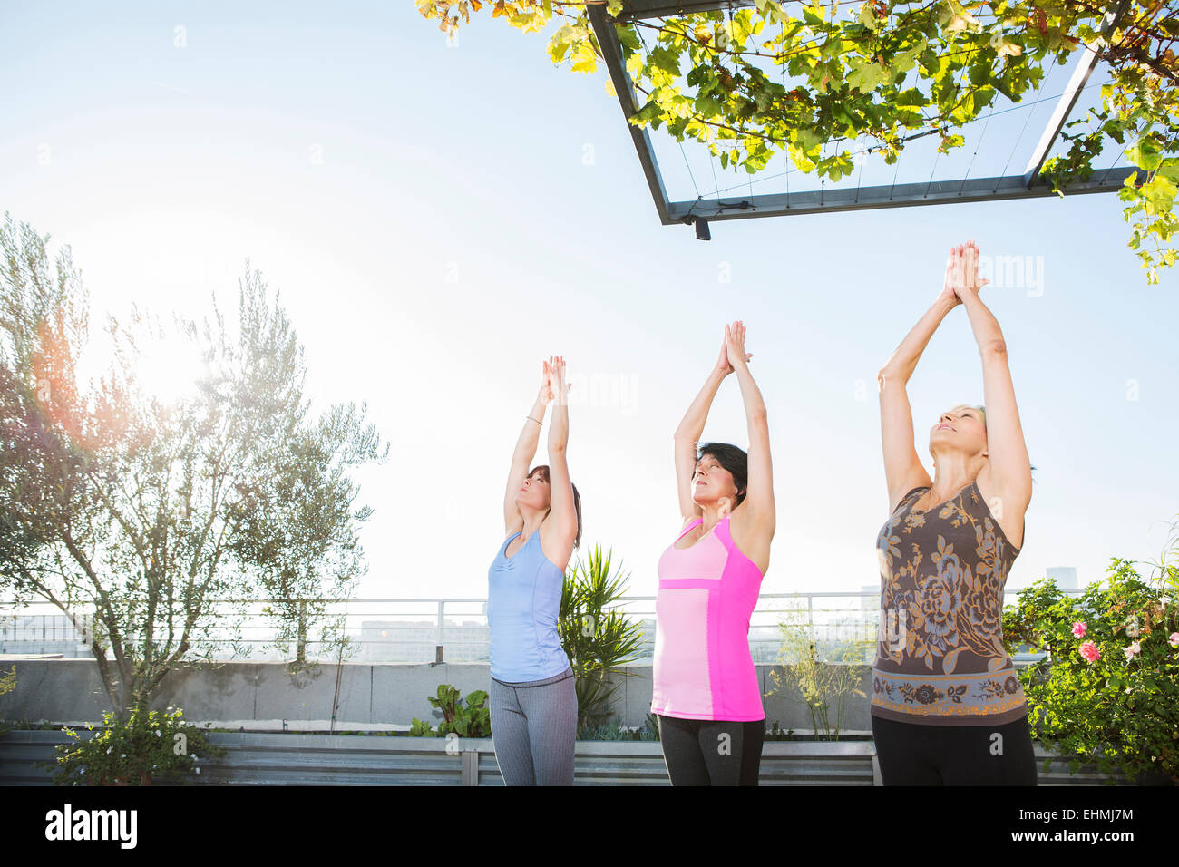Les femmes pratiquant le yoga ensemble on urban rooftop Banque D'Images